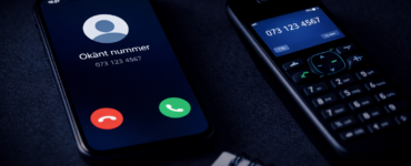 Smartphone og trådløs telefon med ukendt opkald på mørkt bord
