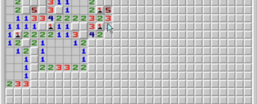 Skärmbild av Röj / Minesweeper i klassisk Windows-stil med grå spelruta, färgade siffror, flaggade minor och smiley-knapp överst.